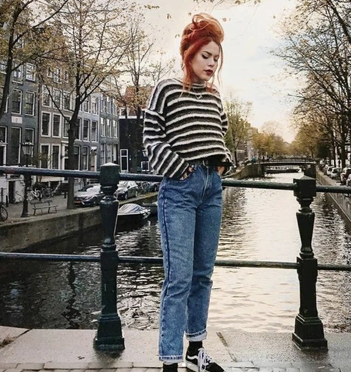 menina posando para foto em pé em frente ao um canal
